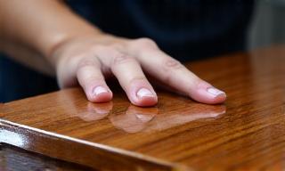 Artisan applying French polish to a furniture surface.