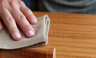 Hand meticulously applying a new wood finish.